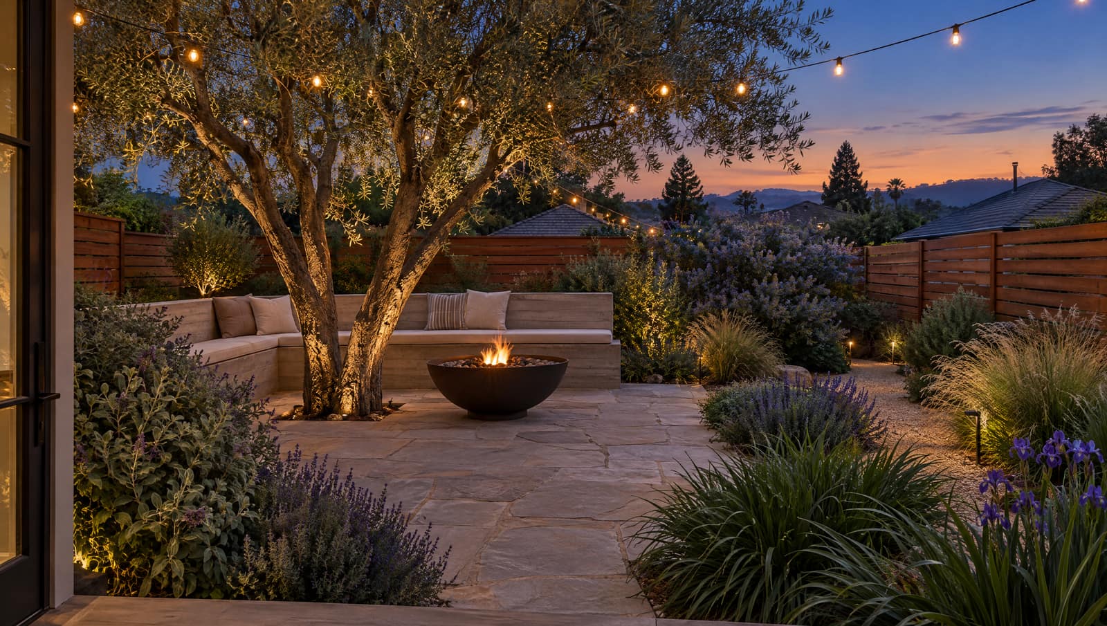 Concept render of a back yard with a flagstone patio, an olive tree, a built-in bench, and a fire bowl.